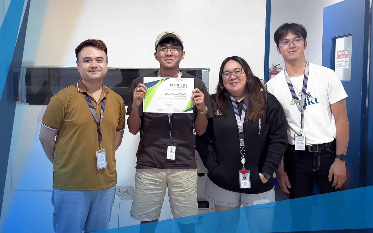 Four team members, one holding a certificate of recognition